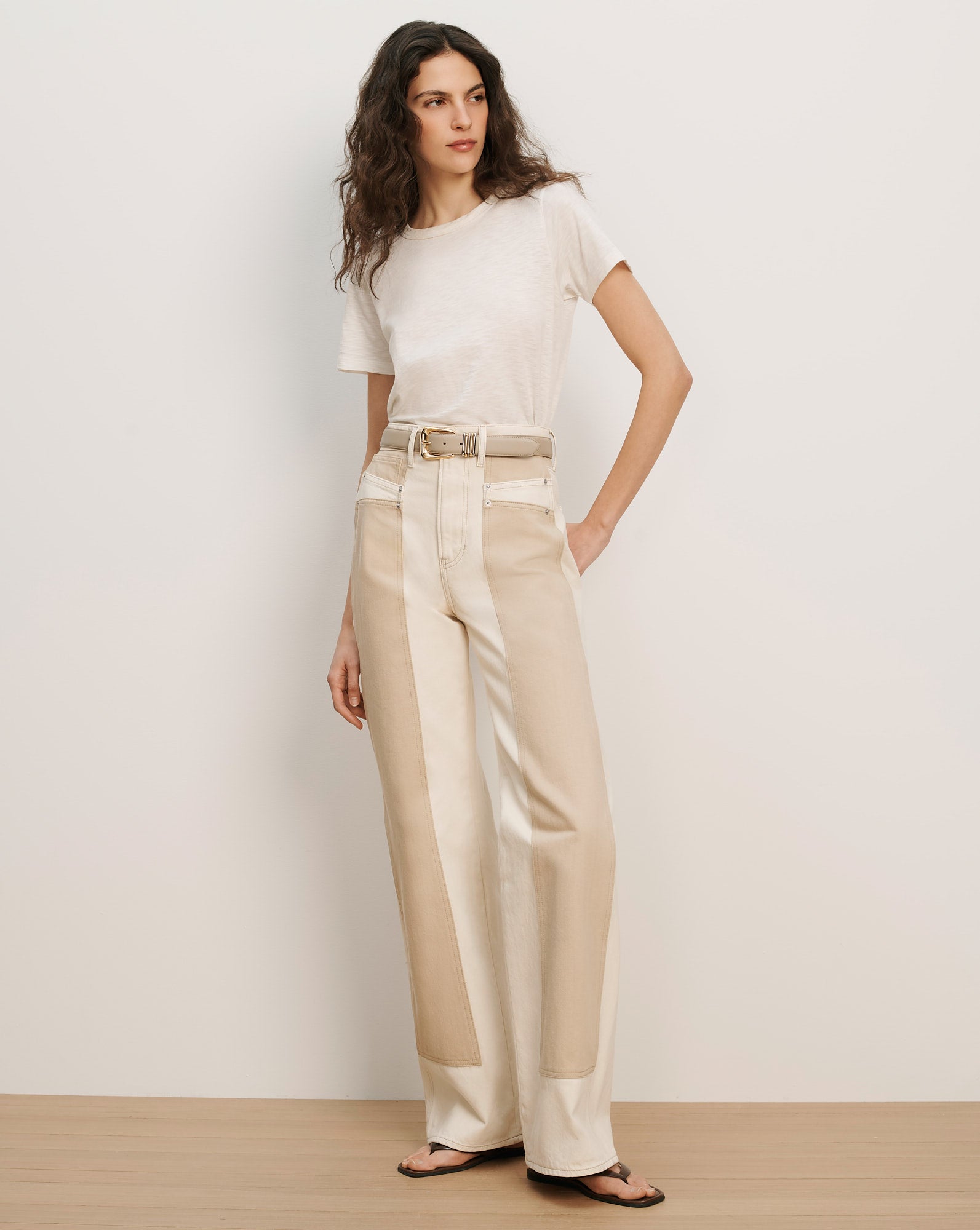 Veronica Beard Cream short-sleeve t-shirt and two-tone beige and cream wide-leg pants with a light beige belt.