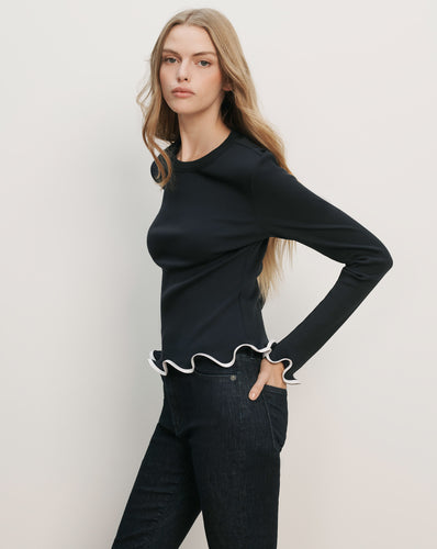 Veronica Beard Navy blue long-sleeve top with white ruffled trim at the hem and cuffs.