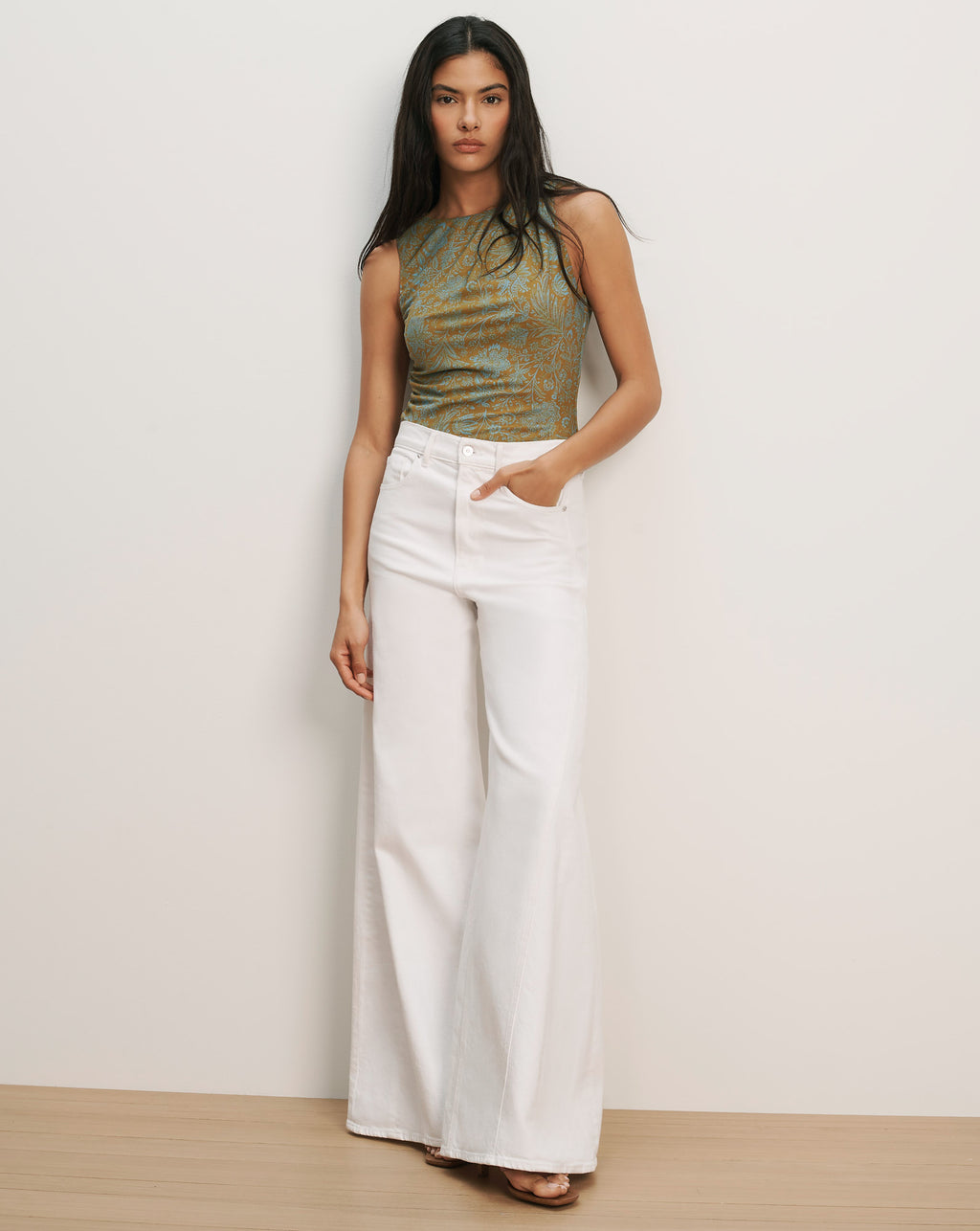 Veronica Beard Sleeveless green and brown patterned knit top with white wide-leg jeans.