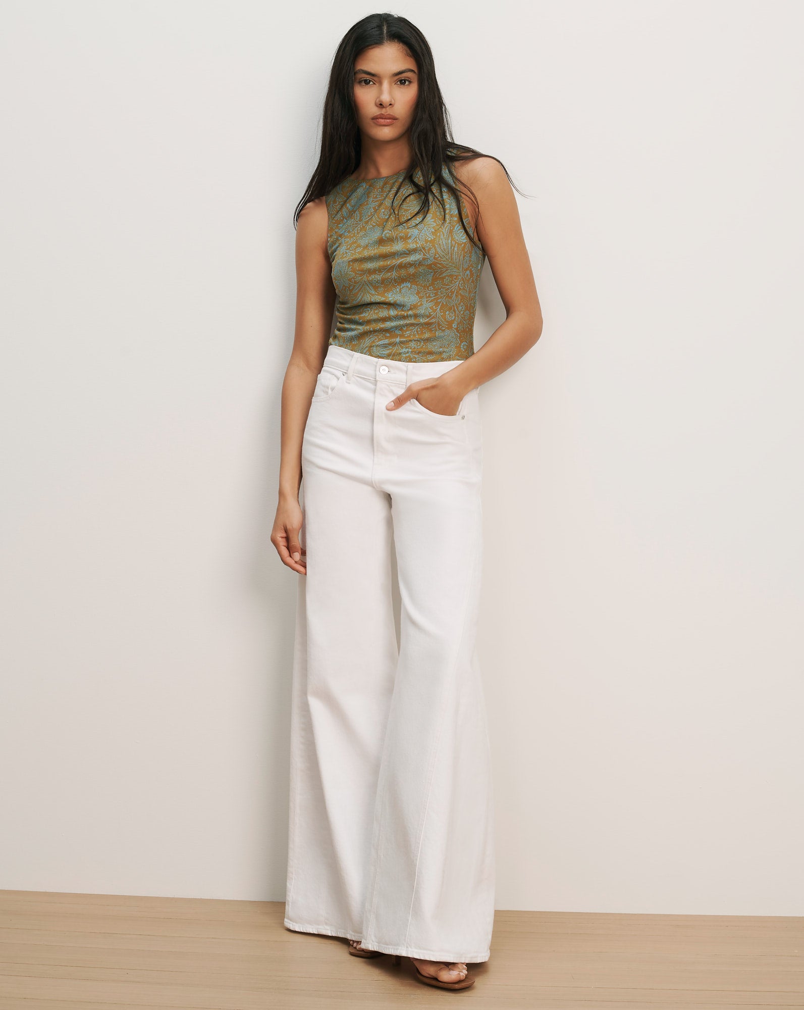 Veronica Beard Sleeveless green and brown patterned knit top with white wide-leg jeans.