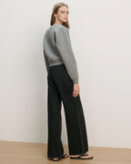Veronica Beard Gray crewneck sweatshirt and black wide-leg jeans with white stitching.