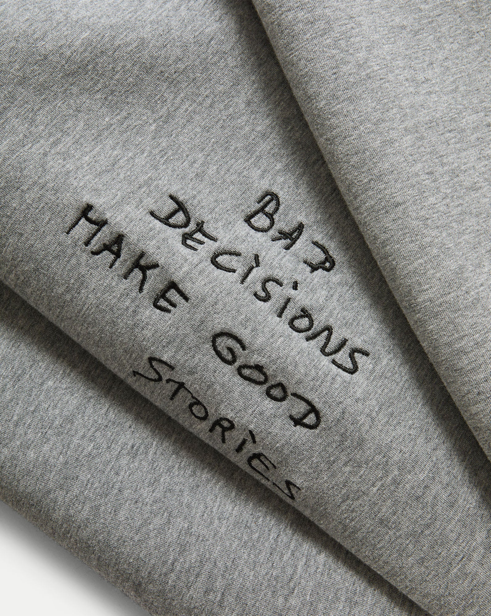 Veronica Beard Gray crewneck sweatshirt and black wide-leg jeans with white stitching.