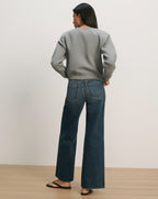 Veronica Beard Gray crewneck sweatshirt and dark wash wide-leg jeans.