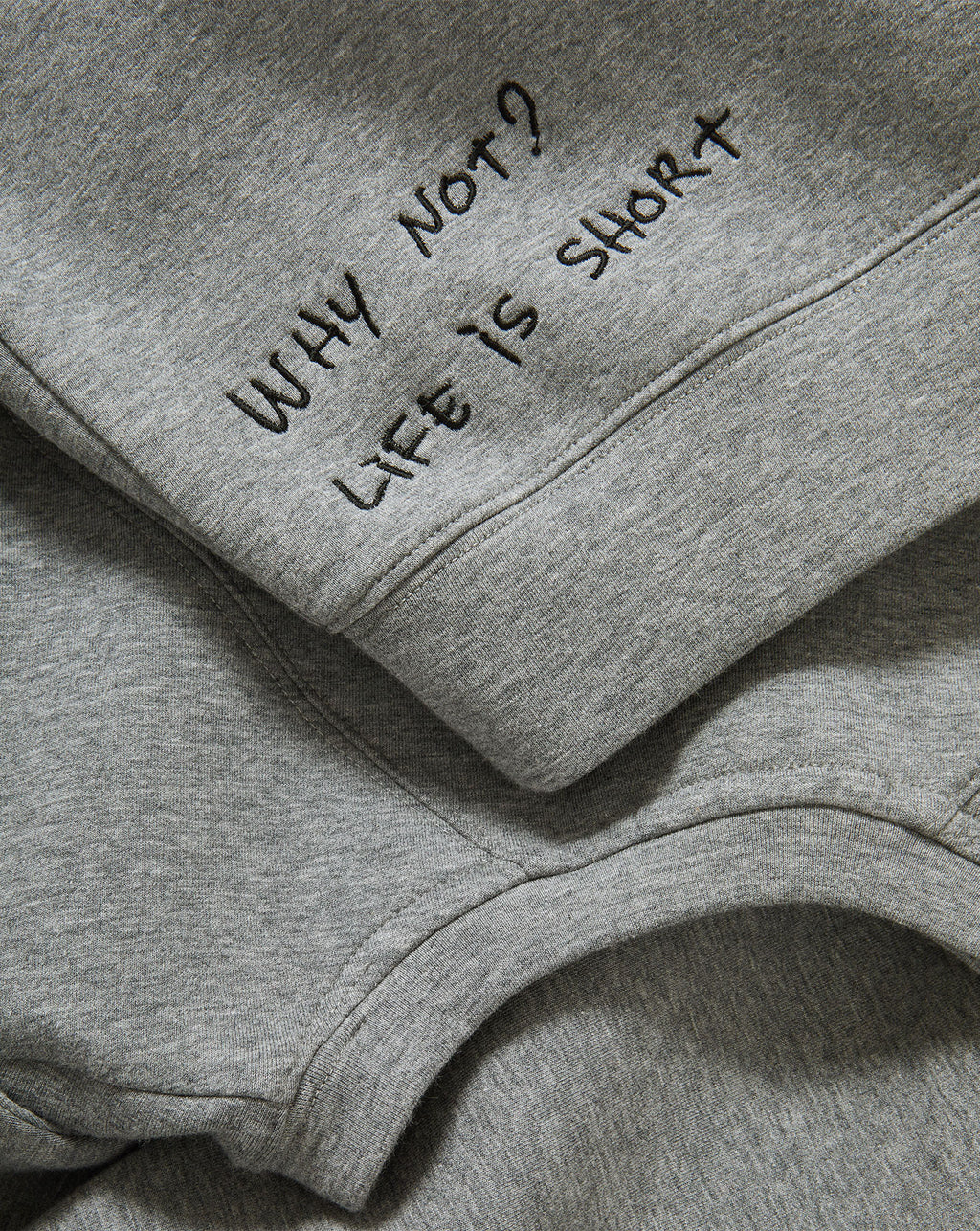 Veronica Beard Gray crewneck sweatshirt with raglan sleeves and dark wash wide-leg jeans with a raw hem.
