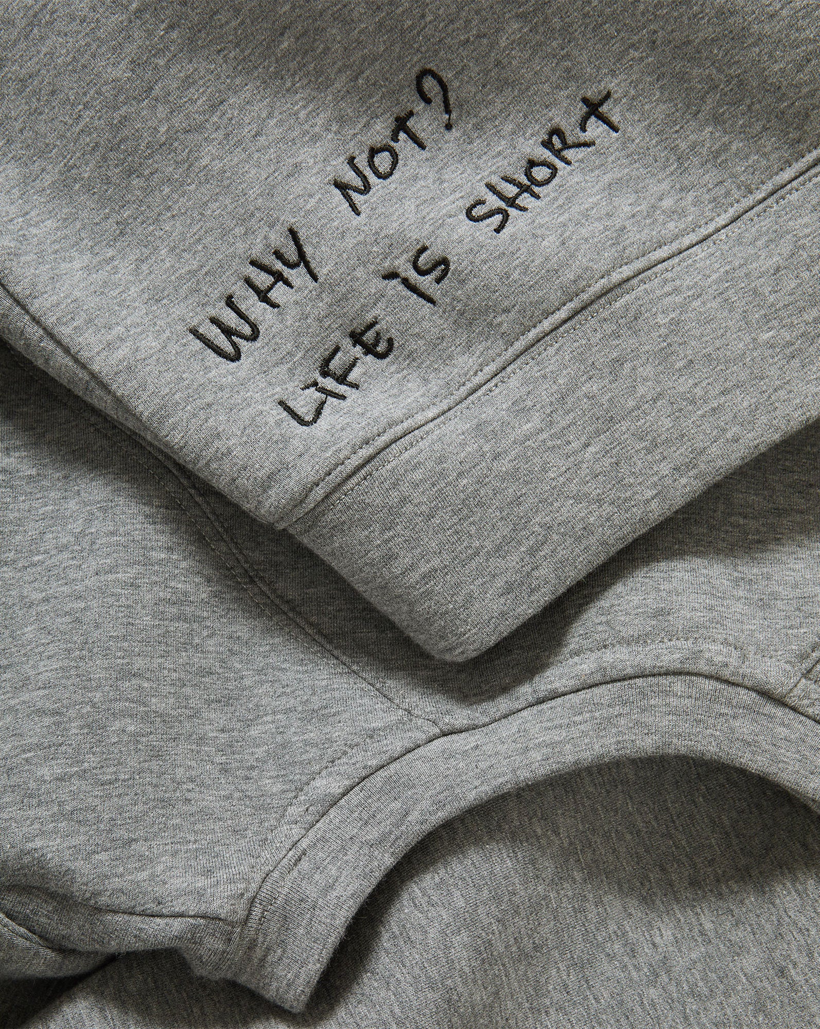 Veronica Beard Gray crewneck sweatshirt with raglan sleeves and dark wash wide-leg jeans with a raw hem.