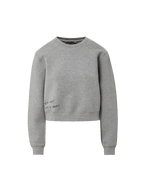 Veronica Beard Gray crewneck sweatshirt with raglan sleeves and dark wash wide-leg jeans with a raw hem.