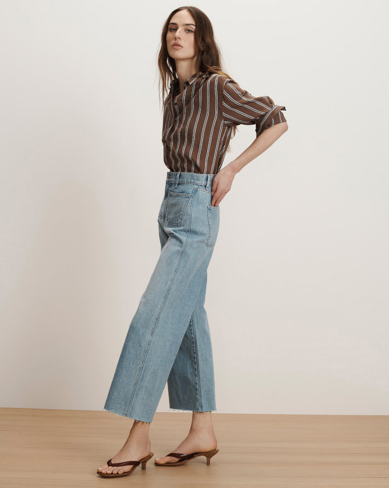 Veronica Beard Brown and white striped button-up shirt with light wash wide-leg jeans and brown kitten heel sandals.