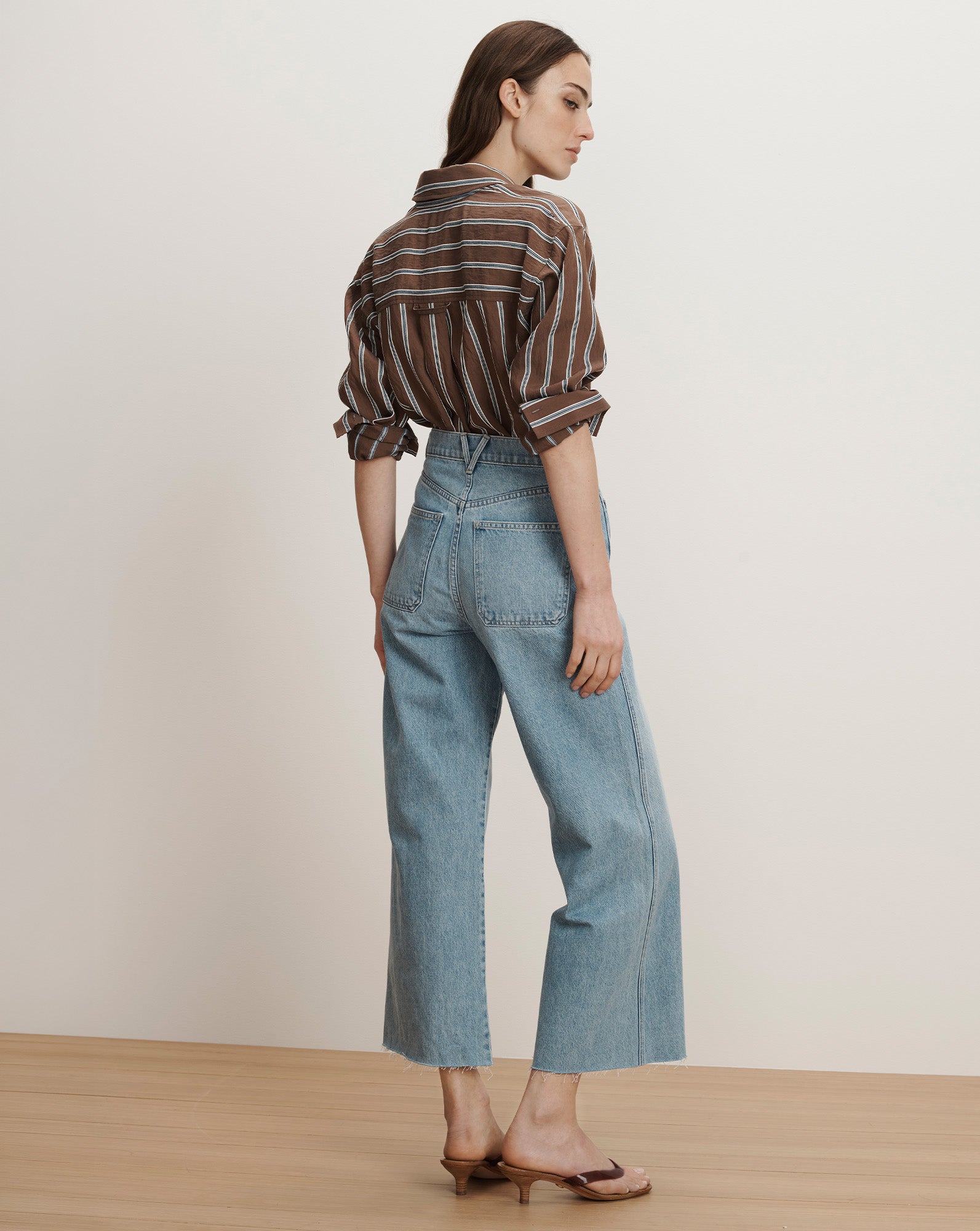 Veronica Beard Brown and white striped button-up shirt with light wash wide-leg cropped jeans.
