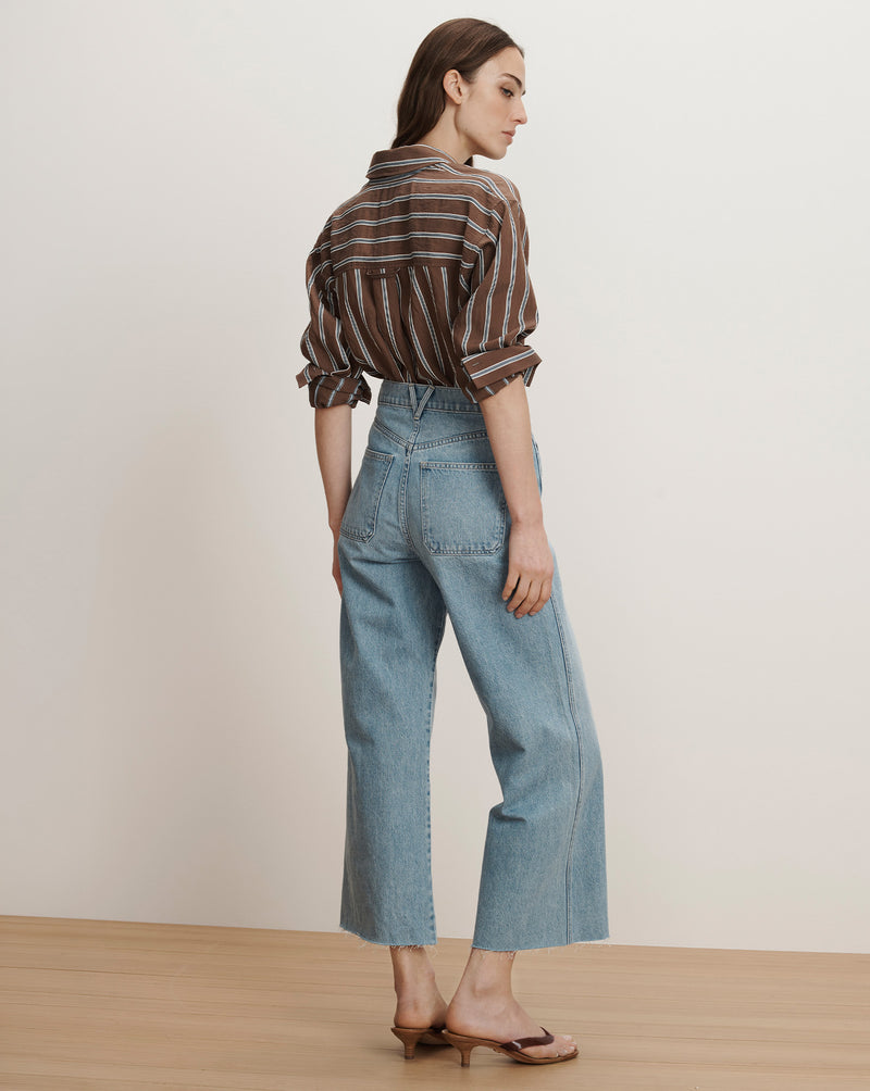 Veronica Beard Brown and white striped button-up shirt with light wash wide-leg cropped jeans.