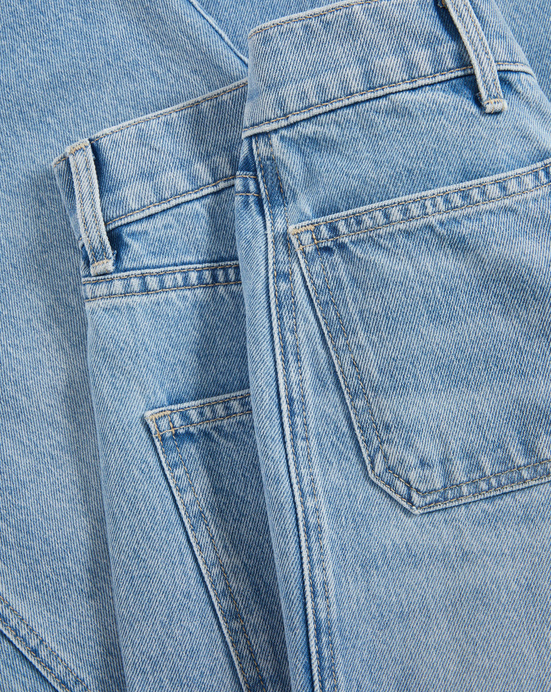 Veronica Beard Brown and white striped sheer button-up shirt with light wash wide-leg jeans.