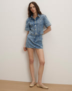 Veronica Beard Light wash denim short-sleeve button-up shirt and matching mini skirt.