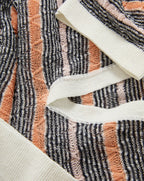 Veronica Beard Gray, peach, and white striped knit polo shirt with a white collar and a light wash denim mini skirt.