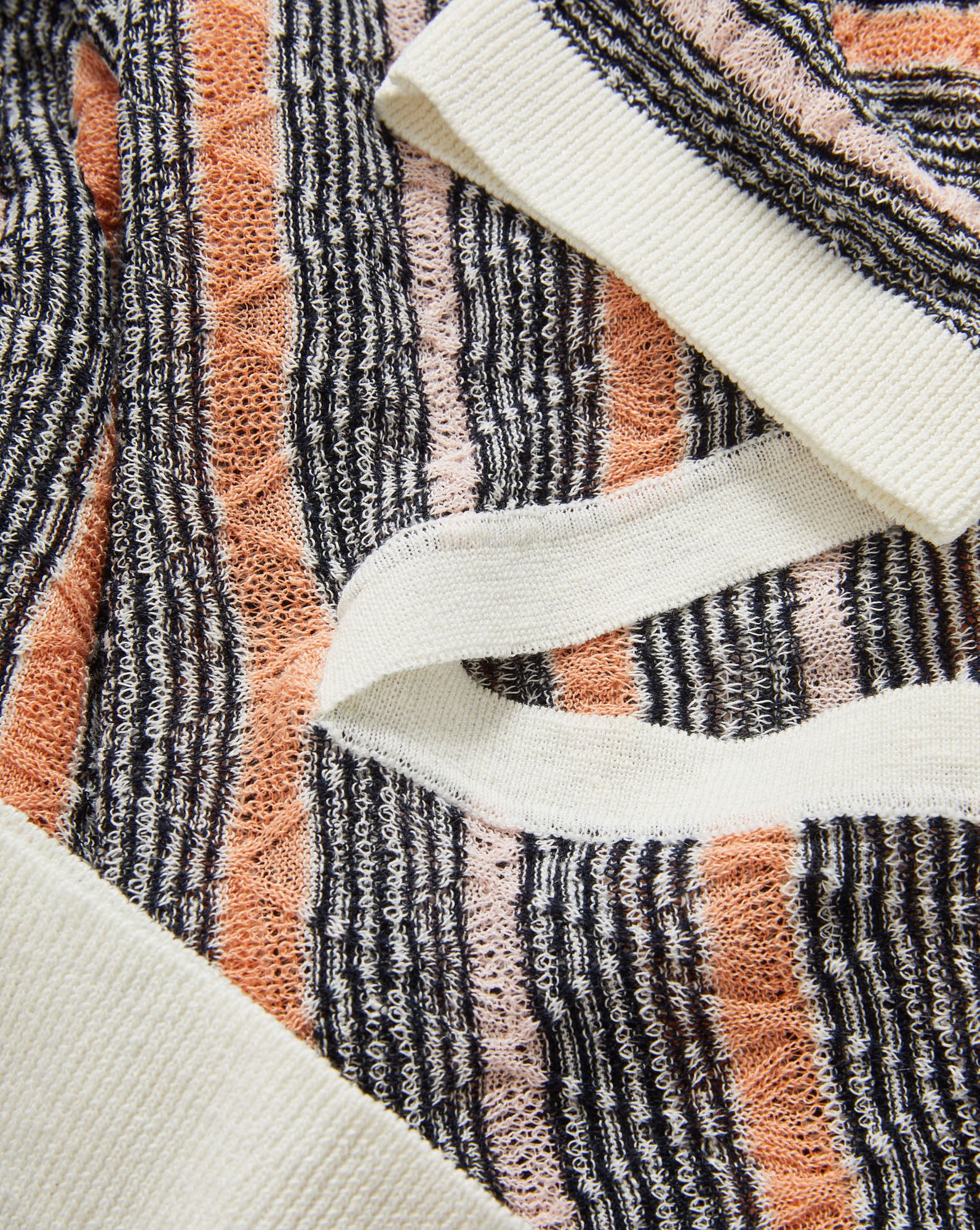 Veronica Beard Gray, peach, and white striped knit polo shirt with a white collar and a light wash denim mini skirt.