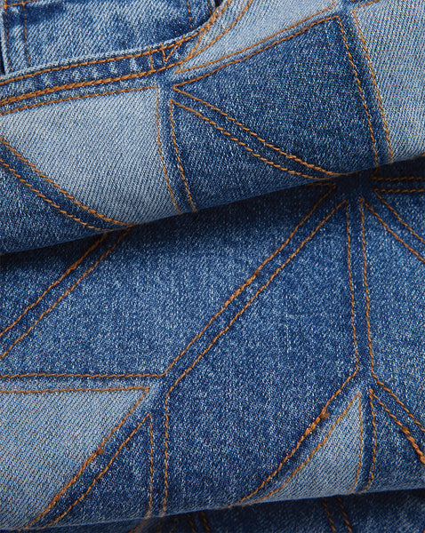 Veronica Beard Blue denim patchwork jeans with light brown stitching.