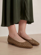 Veronica Beard Brown woven leather flats with a dark green skirt.