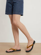 Veronica Beard Black flip-flops with mustard yellow velvet straps.