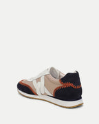Veronica Beard Beige and black leather sneaker with orange stitching.
