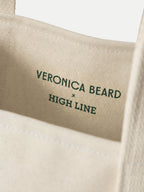 Veronica Beard Beige canvas tote bag with green text.
