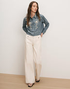 Veronica Beard Blue embroidered button-up shirt and cream wide-leg pants.
