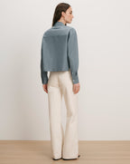 Veronica Beard Blue button-up shirt and cream wide-leg pants.