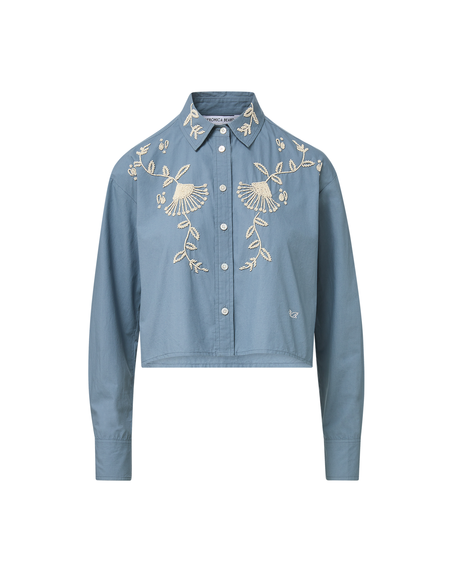 Veronica Beard Blue embroidered button-up shirt and cream wide-leg pants.