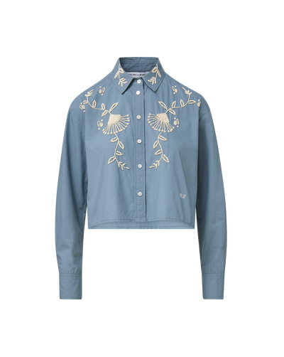 Veronica Beard Blue embroidered button-up shirt and cream wide-leg pants.