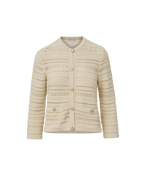 Veronica Beard Cream open-knit cardigan and light wash flared jeans.