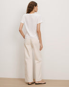 Veronica Beard White cotton t-shirt and cream wide-leg jeans.