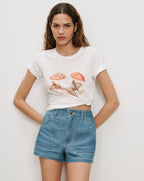 Veronica Beard White graphic tee, light wash denim shorts.