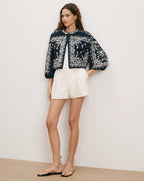 Veronica Beard Black embroidered jacket, white top, and white shorts.