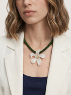 Veronica Beard White flower pendant on a green beaded necklace.