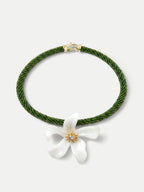 Veronica Beard Green beaded necklace with a white flower pendant.