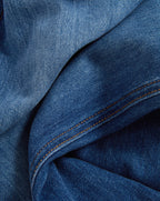 Veronica Beard Beige short-sleeve knit top and wide-leg blue jeans.