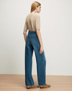 Veronica Beard Beige short-sleeve knit top and wide-leg blue jeans.