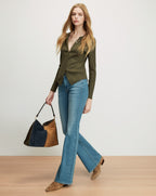 Veronica Beard Olive green ribbed knit cardigan, blue flared jeans.