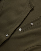 Veronica Beard Olive green ribbed knit cardigan, blue flared jeans.