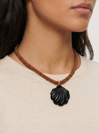 Veronica Beard Brown beaded necklace with a dark shell pendant.