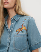 Veronica Beard Blue denim short-sleeve shirt with cowboy embroidery.